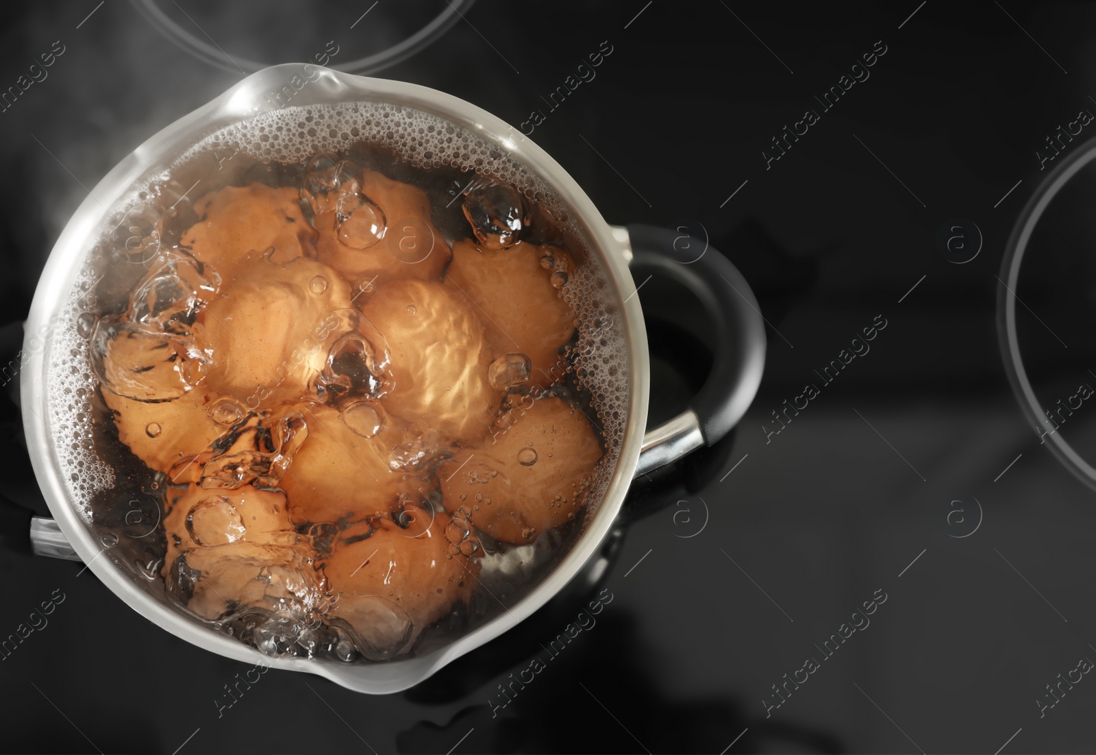 Photo of Cooking chicken eggs in pot on electric stove, top view. Space for text