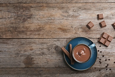 Photo of Cup of hot chocolate on wooden background, flat lay. Space for text