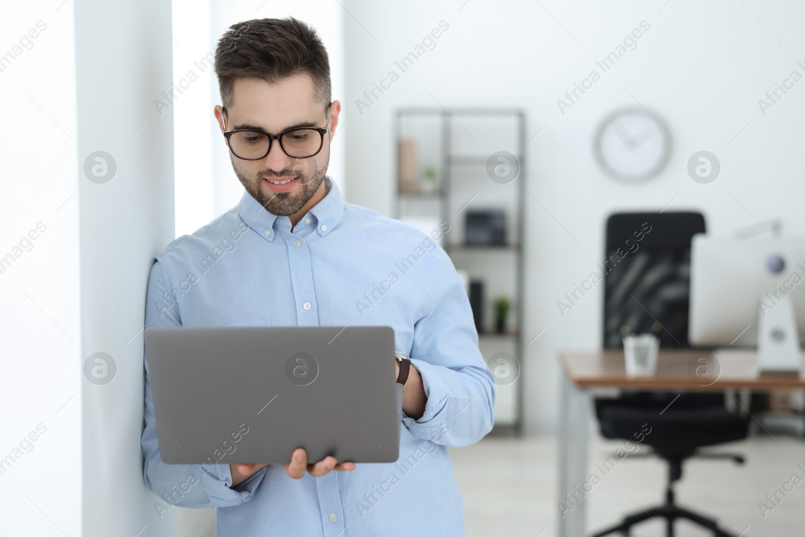 Photo of Young programmer working with laptop in office