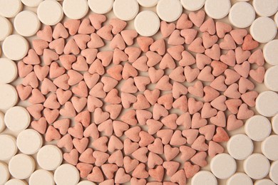 Photo of Heart made of vitamins for pets on beige background, flat lay