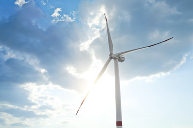 Photo of Modern windmill against sky with clouds, low angle view. Energy efficiency