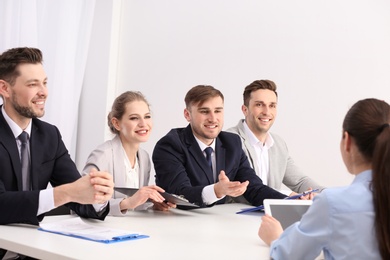 Photo of Human resources commission conducting job interview with applicant, indoors