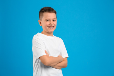 Portrait of preteen boy on light blue background, space for text