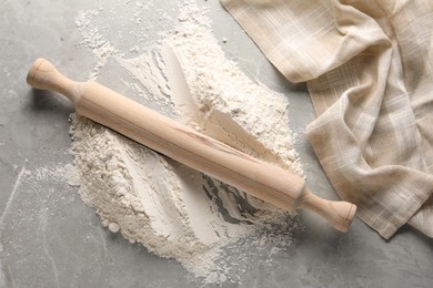 Photo of Pile of flour and rolling pin on grey marble table, top view