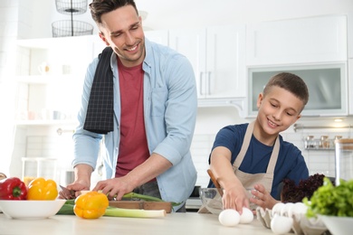 Photo of Dad and son cooking together in kitchen