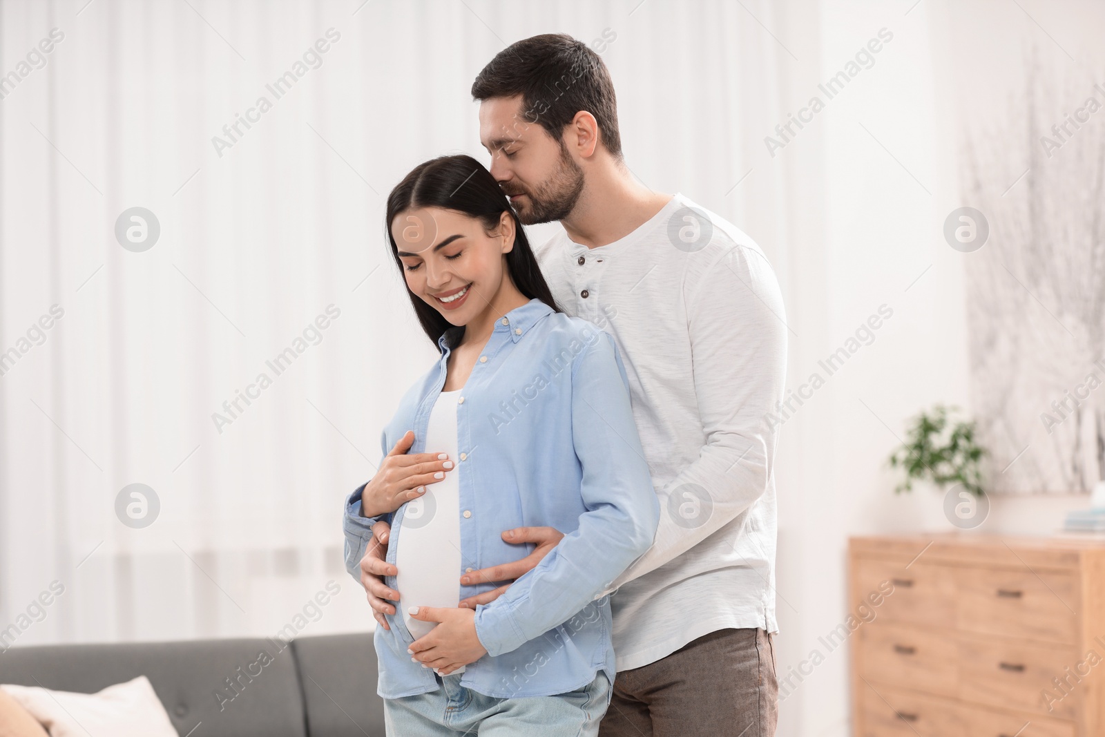 Photo of Happy pregnant woman with her husband at home