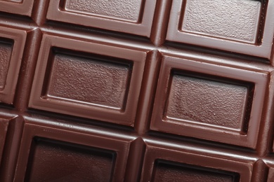 Tasty dark chocolate bar as background, top view