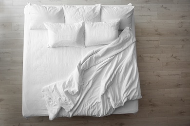 Comfortable bed with soft pillows indoors, top view