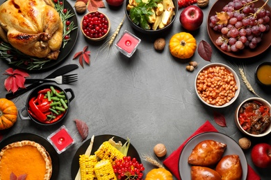 Photo of Traditional Thanksgiving day feast with delicious cooked turkey and other seasonal dishes served on grey table, flat lay. Space for text