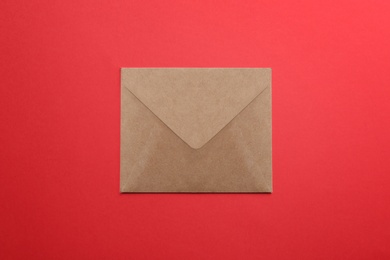Brown paper envelope on red background, top view