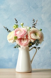 Photo of Vase with beautiful spring ranunculus flowers on table