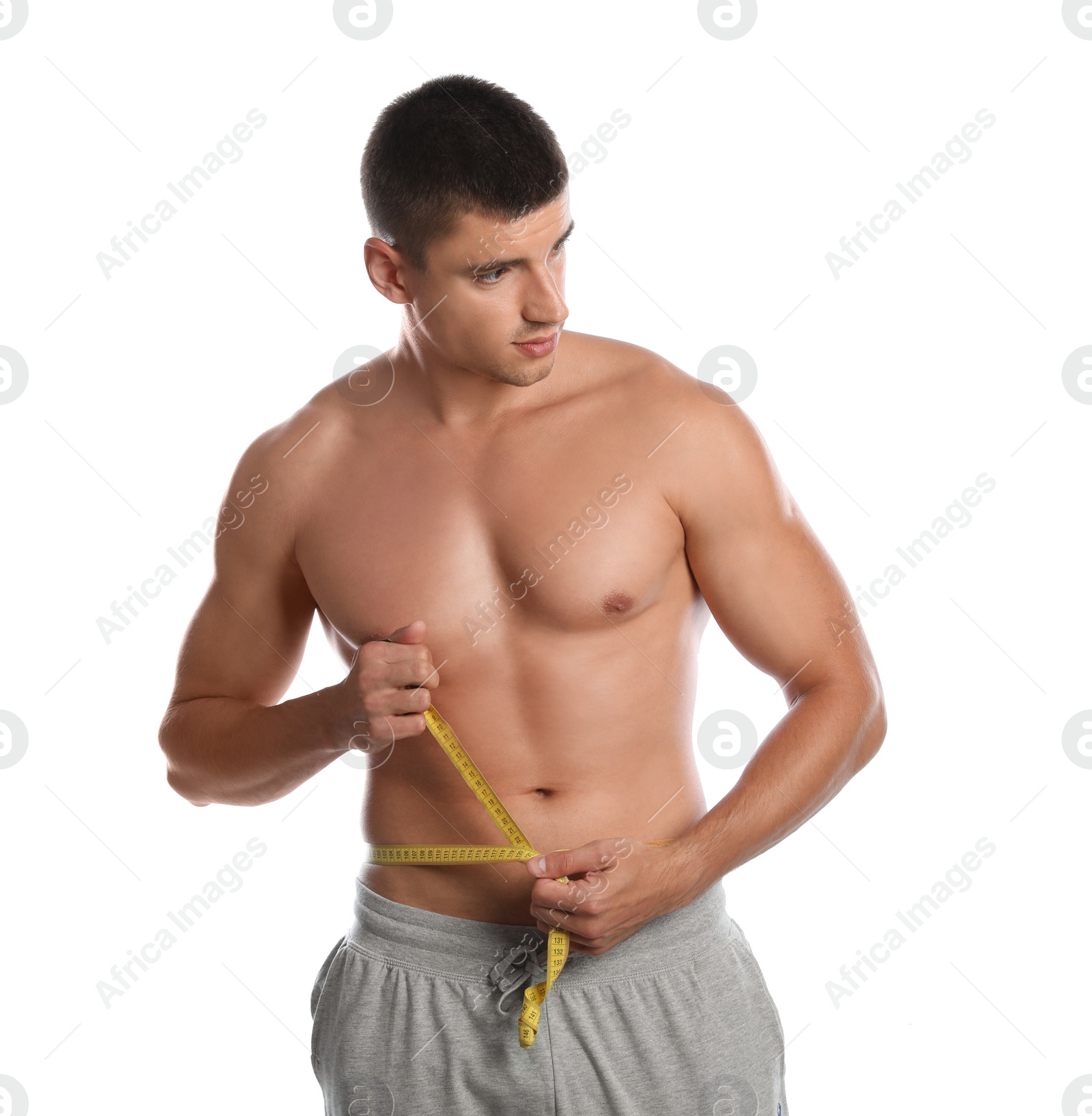 Photo of Young man with slim body using measuring tape on white background