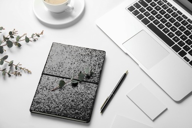 Photo of Composition with glittering notebook and laptop on white background