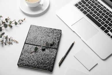 Composition with glittering notebook and laptop on white background