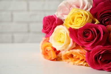 Photo of Luxury bouquet of fresh roses on white wooden table, closeup