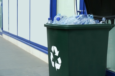 Many used plastic bottles in trash bin outdoors. Recycling problem