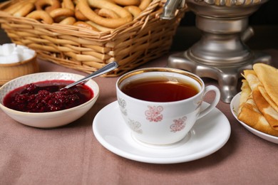 Photo of Aromatic tea and cherry jam on table