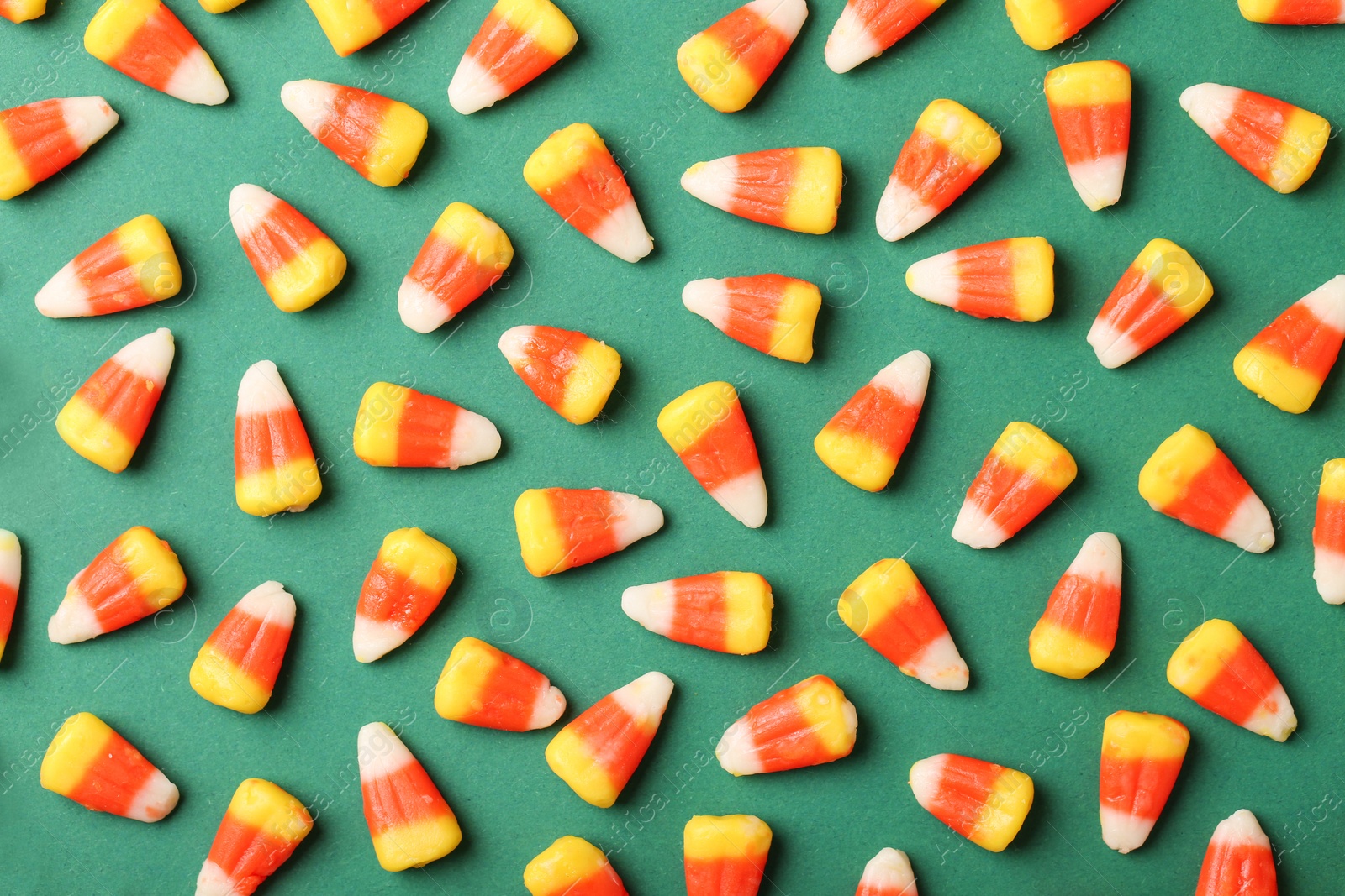 Photo of Flat lay composition with delicious candy corns on color background