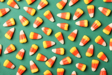 Photo of Flat lay composition with delicious candy corns on color background