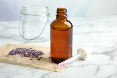 Photo of Natural herbal oil and lavender on marble table