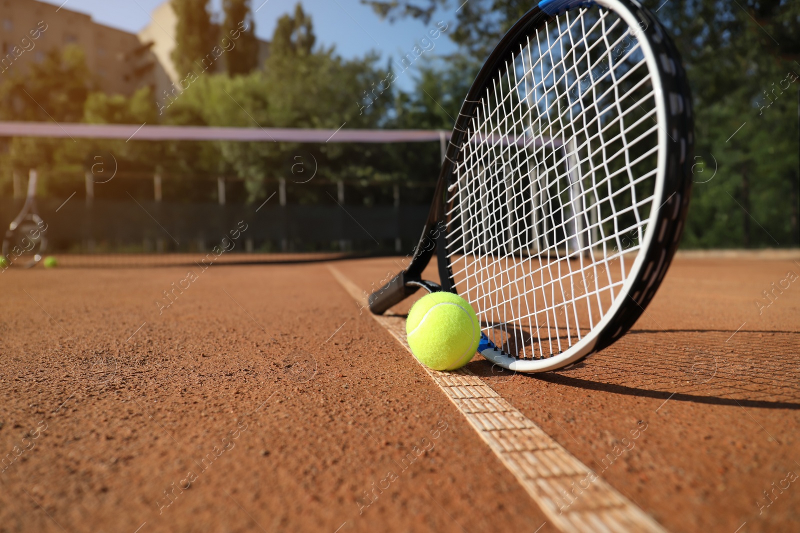 Photo of Tennis ball and racket on clay court