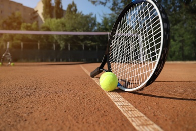 Photo of Tennis ball and racket on clay court