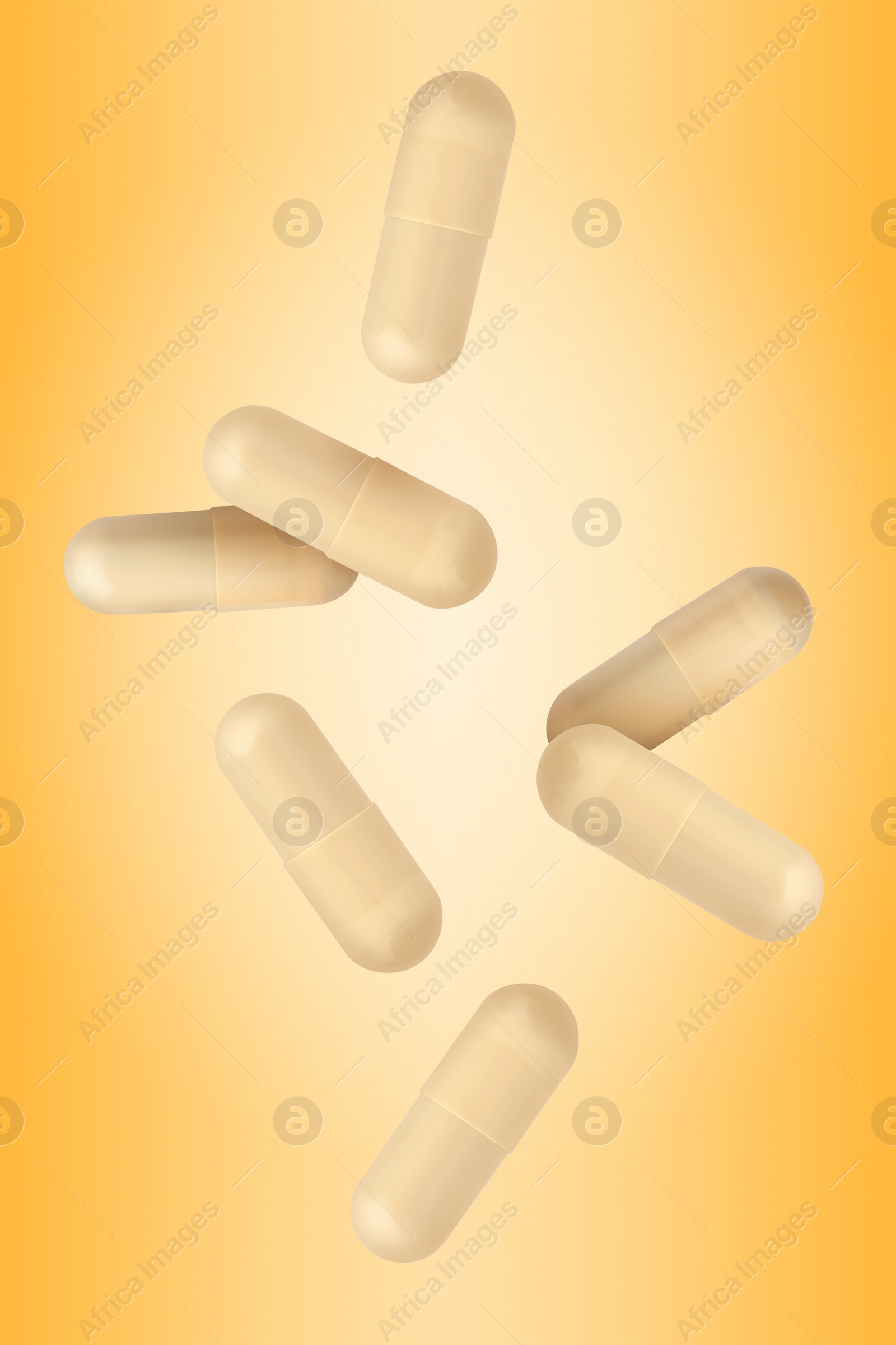 Image of Vitamin. Capsules falling on orange gradient background