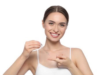 Photo of Young woman applying essential oil onto finger on white background