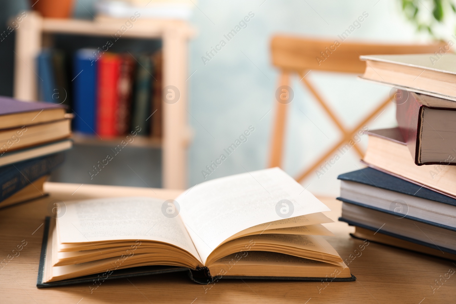 Photo of Open hardcover book on wooden table indoors. Space for text