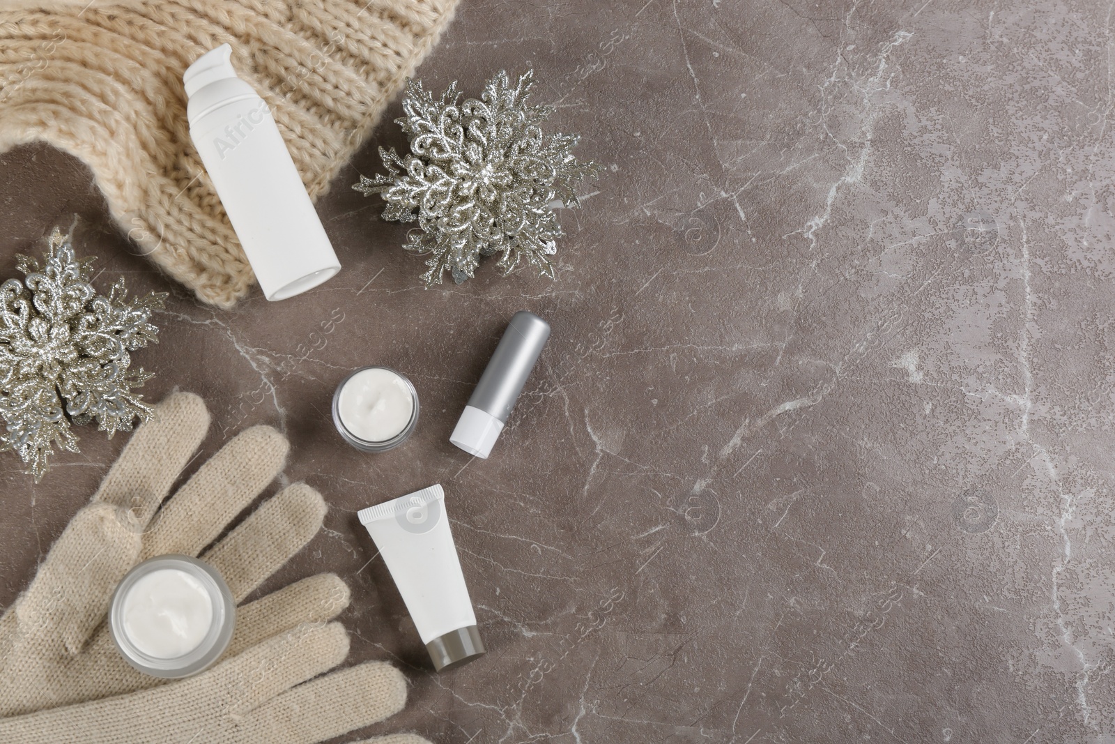 Photo of Flat lay composition with different cosmetic products on grey table, space for text. Winter care