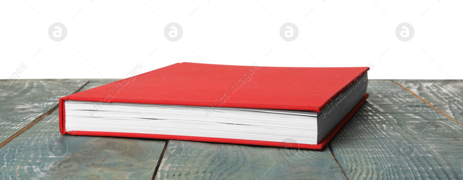 Photo of Book with red cover on wooden table against white background