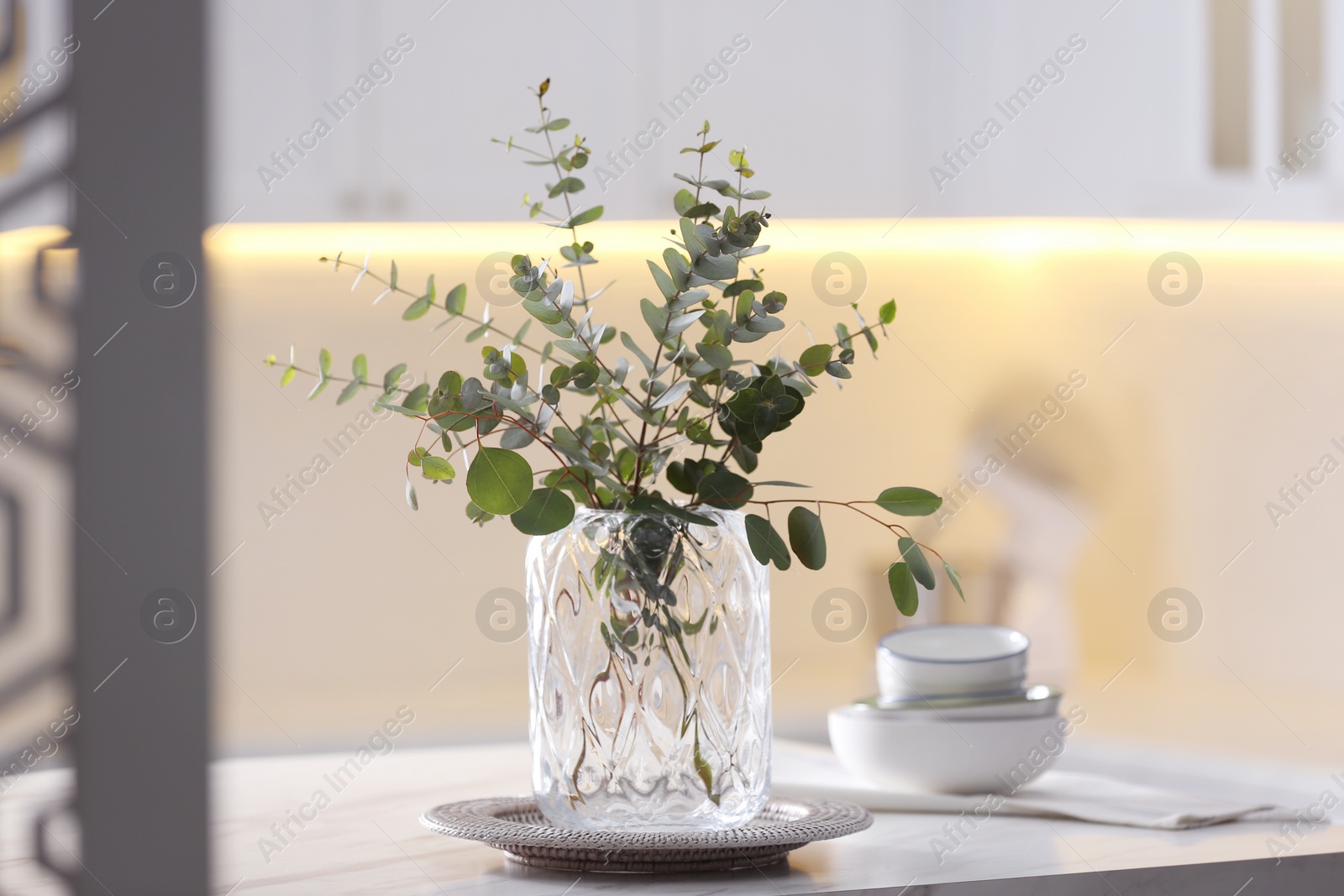 Photo of Beautiful eucalyptus branches on table in modern kitchen. Interior design