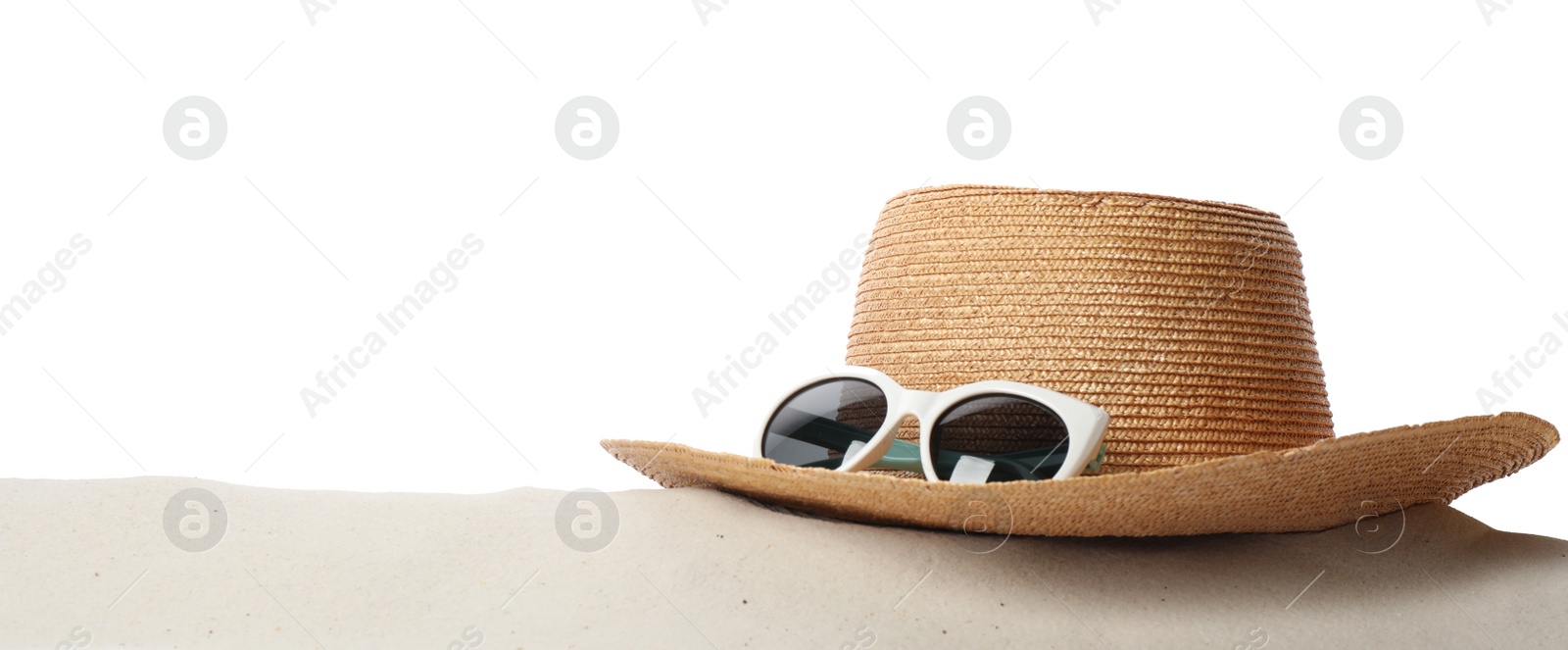 Photo of Hat and sunglasses on sand against white background, space for text. Stylish beach accessories