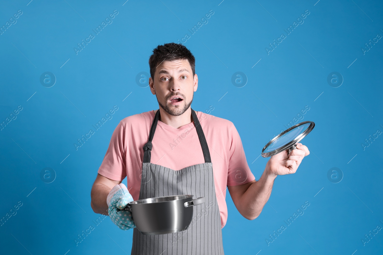 Photo of Surprised man with pot on light blue background