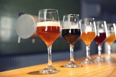 Different sorts of beer on wooden bar counter