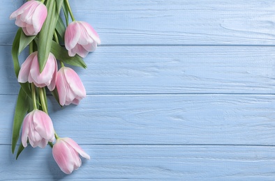 Photo of Beautiful tulips for Mother's Day on wooden background, top view