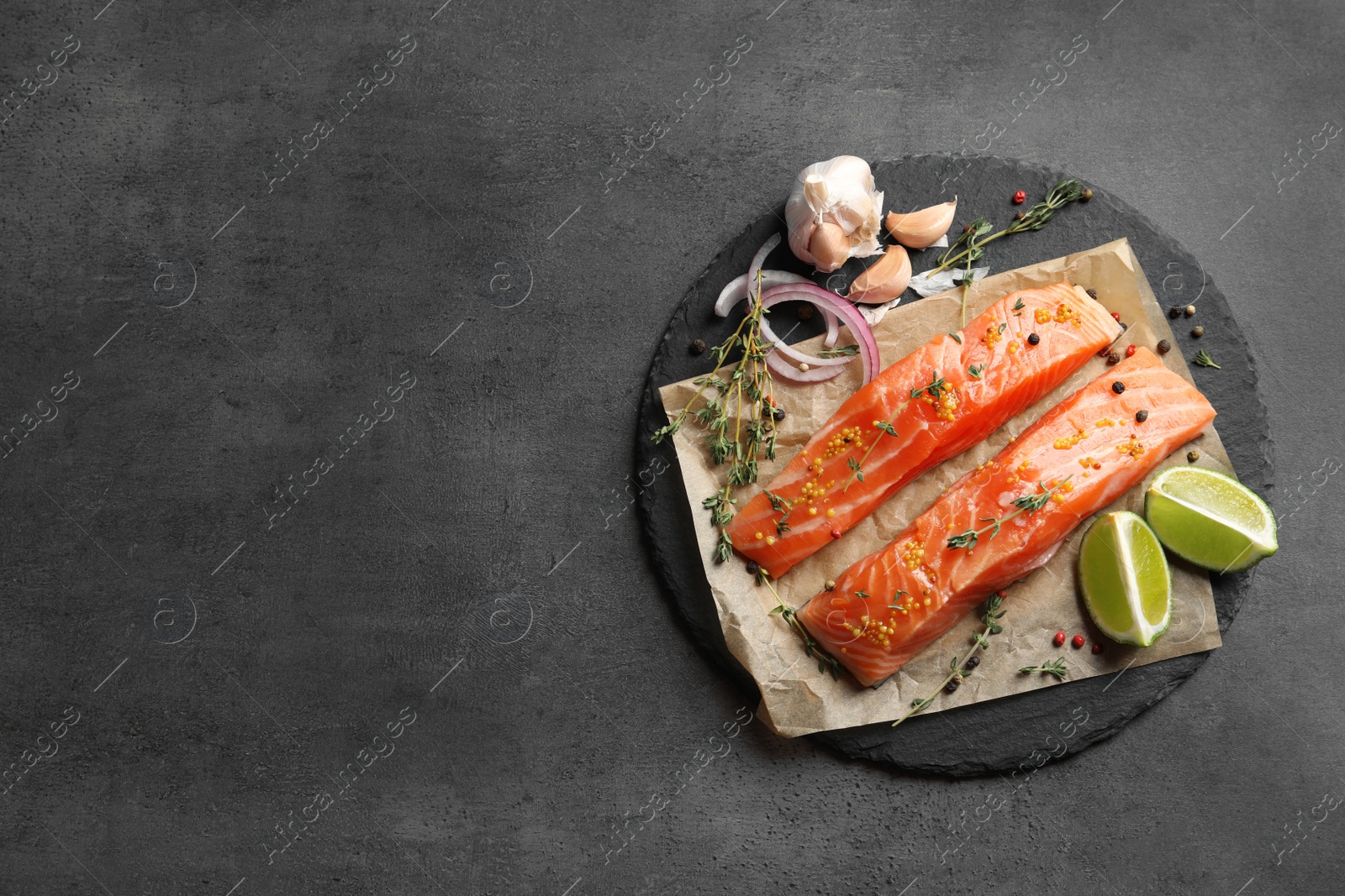 Photo of Fresh salmon and ingredients for marinade on slate plate