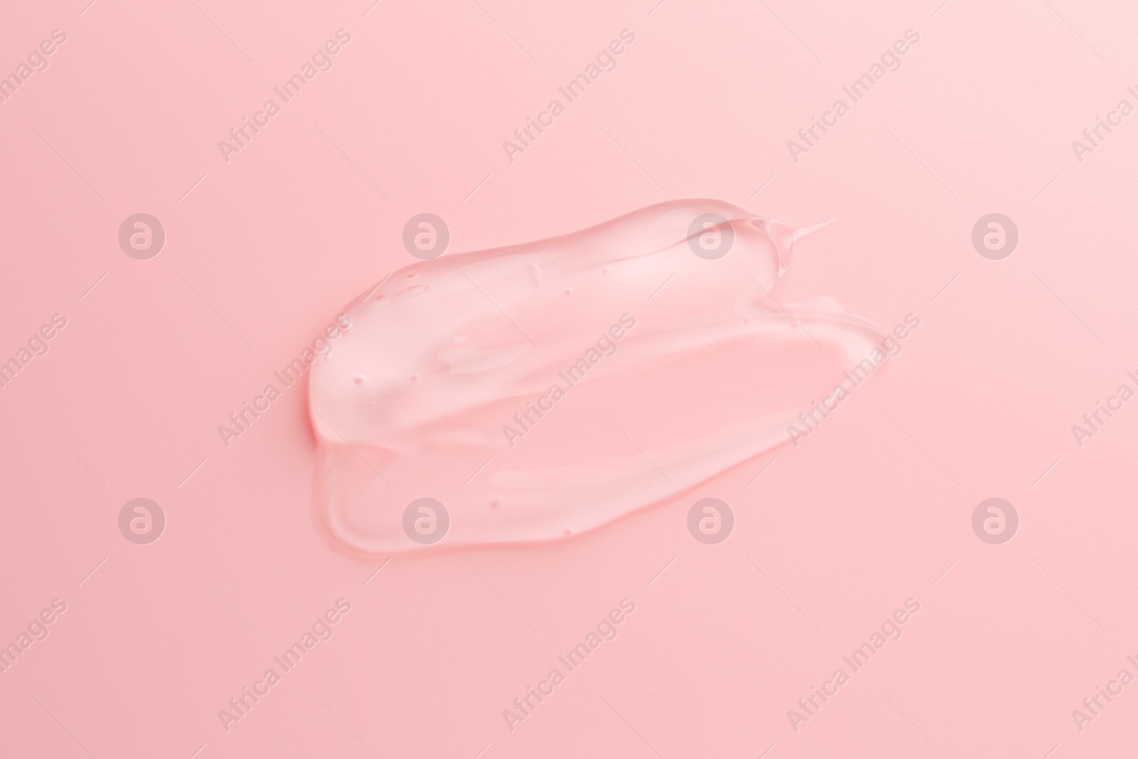 Photo of Sample of transparent gel on pink background, top view