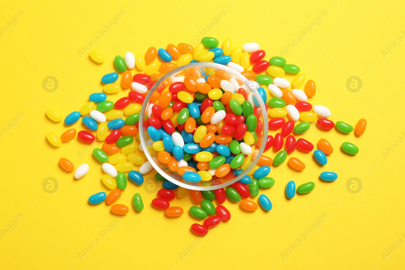 Photo of Bowl of jelly beans on color background, top view