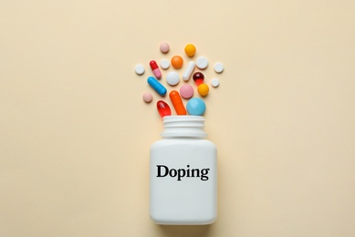 Bottle with drugs on beige background, flat lay. Doping control