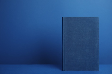 Hardcover book on blue background. Space for design