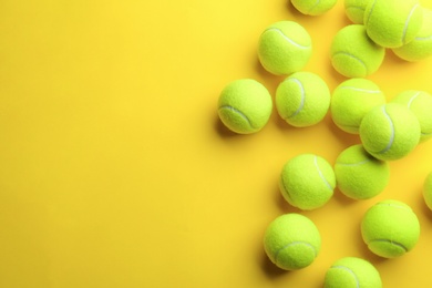 Tennis balls on yellow background, flat lay. Space for text