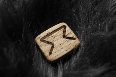 Photo of Wooden rune Perth on grey faux fur, closeup