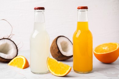 Tasty kombucha in glass bottles and fresh fruits on white table