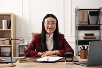 Photo of Portrait of smiling notary at table in office