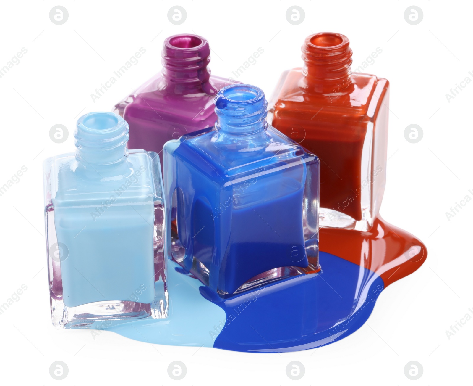 Photo of Puddle of different bright nail polishes and bottles isolated on white