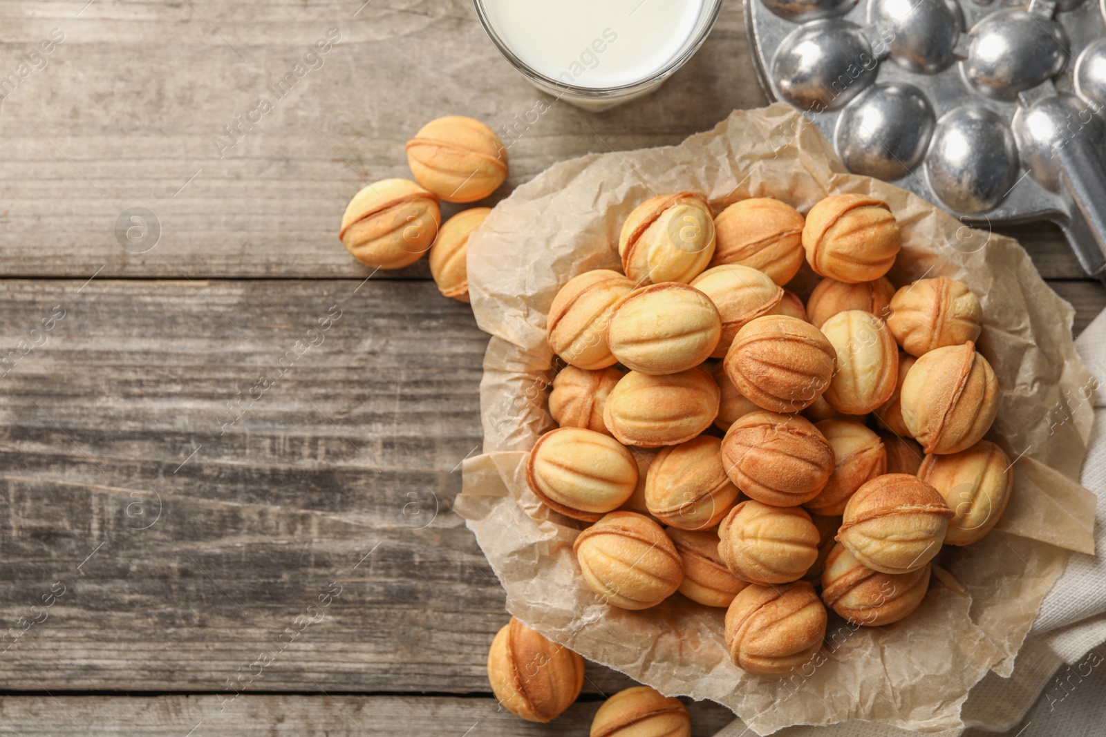 Photo of Bowl of delicious nut shaped cookies on wooden table, flat lay. Space for text