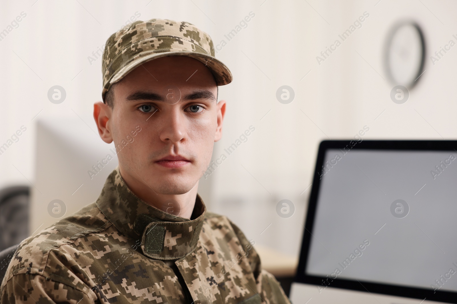 Photo of Military service. Portrait of young soldier in office, space for text