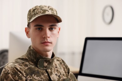 Photo of Military service. Portrait of young soldier in office, space for text