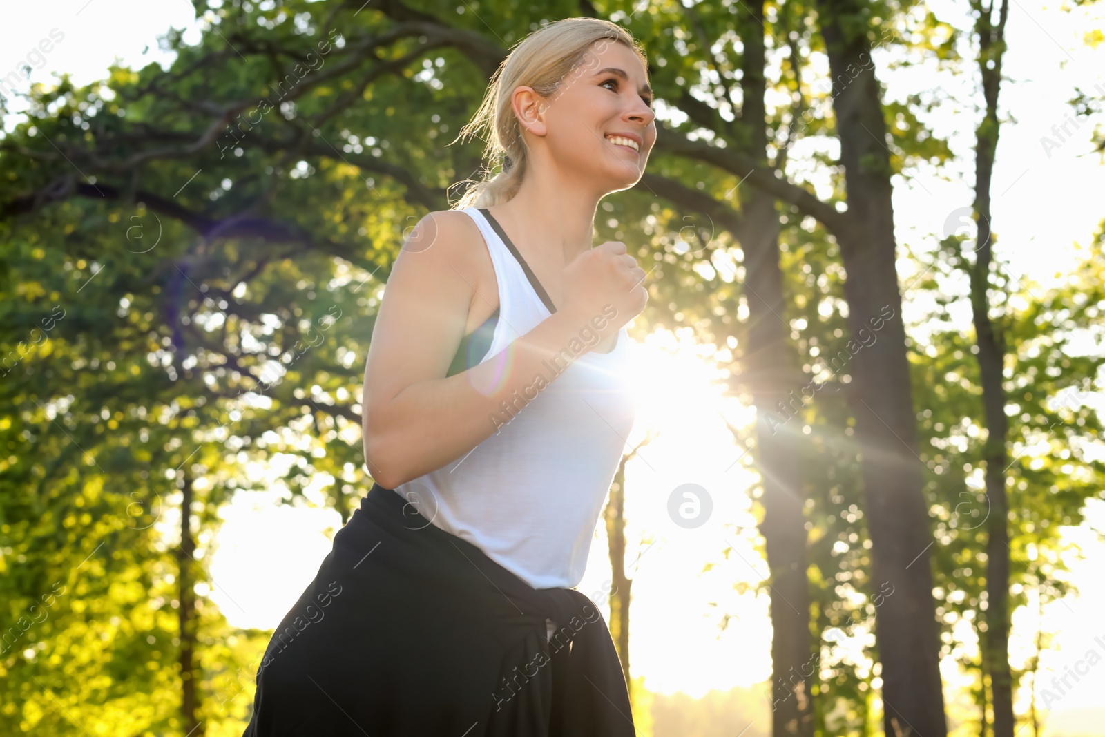 Photo of Woman running outdoors in morning, low angle view